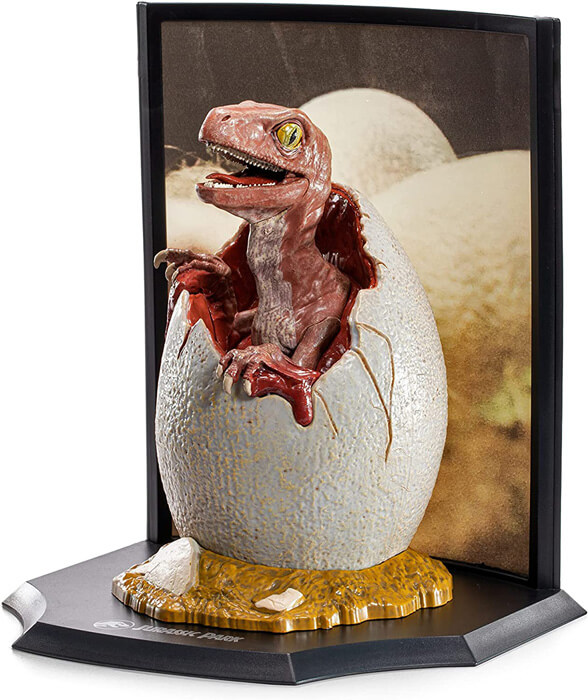 Figurine d un bébé vélociraptor en train de casser la coquille de son oeuf dans le film Jurassic Park collection Toyllectible Treasures 849421008499